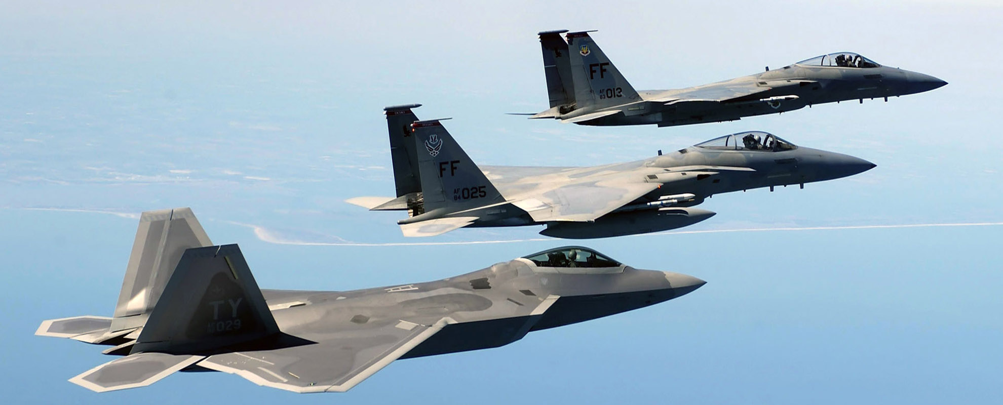 OVER THE ATLANTIC OCEAN -- An F/A-22 Raptor, foreground, flies in formation with two F-15 Eagles en route to a training area off the coast of Virginia on April 5. The F-22 is assigned to the 27th Fighter Squadron and the F-15s are assigned to the 1st Fighter Wing, both at Langley Air Force Base, Va. The Raptor is on loan from Tyndall AFB, Fla. (U.S. Air Force photo by Tech. Sgt. Ben Bloker)